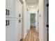 Hallway featuring white storage cabinets, matte black hardware, modern lighting and wood-look floors at 10282 Country Flats Ln, Las Vegas, NV 89135