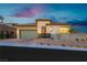 Modern single-story home with light-colored stone exterior and landscaped yard at 11700 Belorado Ave, Las Vegas, NV 89138