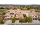 Aerial view of three houses with solar panels, landscaping, and a golf course in the background at 1172 Via Della Costrella, Henderson, NV 89011