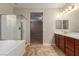 Bathroom showcasing a shower, tub, double vanity and tile flooring leading into the bedroom at 1172 Via Della Costrella, Henderson, NV 89011