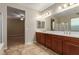 Bright bathroom with double sinks, cherry cabinets, and vanity lighting, and tile flooring at 1172 Via Della Costrella, Henderson, NV 89011