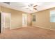 Neutral bedroom with carpet, bright windows, ceiling fan, and an ensuite bath for added privacy at 1172 Via Della Costrella, Henderson, NV 89011