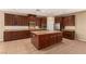 Spacious kitchen showcasing a central island, stainless steel appliances, granite countertops, and dark wood cabinetry at 1172 Via Della Costrella, Henderson, NV 89011