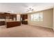 Open-concept living area featuring neutral walls, plush carpeting, and dark wood cabinets with granite counters at 1172 Via Della Costrella, Henderson, NV 89011