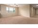 Neutral-toned living room featuring a large window, plush carpet, and plenty of natural light at 1172 Via Della Costrella, Henderson, NV 89011