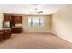 Neutral carpeted living room next to the kitchen with granite countertops and stainless steel appliances at 1172 Via Della Costrella, Henderson, NV 89011