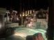 Night view of a luxurious pool and spa with a rock waterfall feature at 2107 Inverness Dr, Henderson, NV 89074