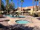 Community pool and spa with lounge chairs and umbrellas at 2120 Ramrod Ave # 1721, Henderson, NV 89014