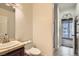 Well-lit half bath with tile floor, vanity sink, and a decorative shower door at 217 Via Luna Rosa Ct, Henderson, NV 89011