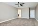 This is a bedroom featuring neutral walls, large windows, ceiling fan, and neutral carpet at 217 Via Luna Rosa Ct, Henderson, NV 89011