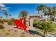 Sculpture and stone entrance to Chimera Golf Club with lush landscaping and palm trees, creating an inviting atmosphere at 217 Via Luna Rosa Ct, Henderson, NV 89011