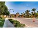 Grand Tuscan-style community entrance with meticulously landscaped grounds and palm trees against a clear blue sky at 217 Via Luna Rosa Ct, Henderson, NV 89011