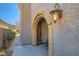 Home featuring an arched entry, light fixture, and tiled walkway leading to the charming front door at 217 Via Luna Rosa Ct, Henderson, NV 89011