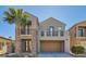 Two-story home showcasing neutral stucco, stacked stone, balcony, decorative trim, arched entry, two-car garage and mature palm tree at 217 Via Luna Rosa Ct, Henderson, NV 89011