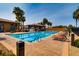 Inviting community pool with lounge chairs, cabana, and palm trees, perfect for relaxation and recreation under sunny skies at 217 Via Luna Rosa Ct, Henderson, NV 89011