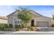 Tan house with a 2-car garage, neatly landscaped front yard, and a tree at 2364 Boretto St, Henderson, NV 89044