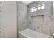 Modern bathroom with marble tile, a bathtub, and a built-in shelf at 2633 S Durango Dr # 201, Las Vegas, NV 89117