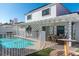 Pool area with a covered patio, outdoor seating, lush landscaping and privacy fencing at 3008 Blue Fin Cir, Las Vegas, NV 89128