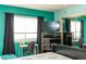 This cozy bedroom features teal walls, a large window, and a desk with a chair at 3008 Blue Fin Cir, Las Vegas, NV 89128