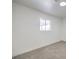 Bright bedroom with a large window and neutral carpet and baseboards at 3012 Holly Hill Ave, Las Vegas, NV 89104