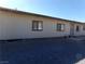 Light beige single story home with gravel parking area at 3381 W Simkins Rd, Pahrump, NV 89060