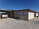 Ranch-style home with a covered parking area, desert landscaping and ample parking at 3381 W Simkins Rd, Pahrump, NV 89060