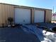 Tan metal garage with two roll-up doors and ample space at 3381 W Simkins Rd, Pahrump, NV 89060