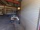 Spacious garage with metal walls, shelving, tools and a roll-up door at 3381 W Simkins Rd, Pahrump, NV 89060