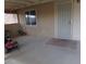 Covered patio area with concrete flooring, features a white security door and window offering a relaxing outdoor space at 3381 W Simkins Rd, Pahrump, NV 89060