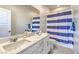 Clean bathroom with double vanity and blue and white striped shower curtain at 4390 E Cactus Canyon Dr, Pahrump, NV 89061