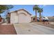 Single story home with a two-car garage and desert landscaping at 4527 Buddy Holly Ct, North Las Vegas, NV 89031