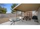 Covered patio with glass-top table and benches at 4527 Buddy Holly Ct, North Las Vegas, NV 89031