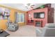 Living room with gray armchairs, fireplace, and large TV at 4826 Polar Lights Ct, Las Vegas, NV 89130