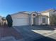 Front view of a house with a two-car garage and desert landscaping at 5005 Prairie Springs Ct, Las Vegas, NV 89130