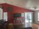 Living area with a red accent wall, large TV, and sliding glass doors at 5005 Prairie Springs Ct, Las Vegas, NV 89130