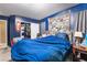 Blue bedroom with double bed, closet, and collage wall decor at 5916 Magic Oak St, North Las Vegas, NV 89031