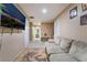 Living area with a couch, a large TV, and a view down a hallway at 5916 Magic Oak St, North Las Vegas, NV 89031