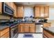 Kitchen with oak cabinets, granite countertops, and stainless steel appliances at 5916 Magic Oak St, North Las Vegas, NV 89031