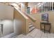 Indoor staircase with light brown carpeting and a small table at the bottom at 5916 Magic Oak St, North Las Vegas, NV 89031