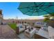 Inviting backyard features a cozy seating area under an umbrella, a manicured lawn, and a privacy wall at 7073 Range Valley St, North Las Vegas, NV 89084