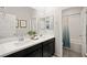 Bright bathroom featuring a double sink vanity, framed mirrors, and a shower/tub combo with a curtain at 7073 Range Valley St, North Las Vegas, NV 89084