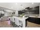 Modern kitchen featuring dark cabinets, quartz countertops, stainless appliances, and bar seating at 7073 Range Valley St, North Las Vegas, NV 89084