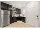 A kitchenette features stainless steel appliances, dark cabinets, and a tiled backsplash near the front door at 7073 Range Valley St, North Las Vegas, NV 89084