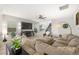 Inviting living room featuring a large sectional sofa, ceiling fan, and modern decor at 7073 Range Valley St, North Las Vegas, NV 89084