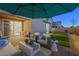 Outdoor patio area with a sun umbrella and cozy seating arrangement at 7073 Range Valley St, North Las Vegas, NV 89084