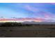 Distant view of city homes with mountain backdrop under a colorful sky at 7073 Range Valley St, North Las Vegas, NV 89084