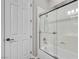 Bathroom featuring a shower and bathtub combination with a glass shower door and white walls at 7288 Olsen Farm St, Las Vegas, NV 89131