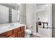 Well-lit bathroom with double sinks, wood cabinetry, and a view to a home office at 7288 Olsen Farm St, Las Vegas, NV 89131