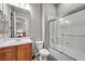 Well-lit bathroom features a shower-tub combo with glass doors and wood vanity at 7288 Olsen Farm St, Las Vegas, NV 89131