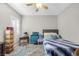 Bedroom with plantation shutters, side tables, a bed with patterned blue comforter, and neutral walls at 7288 Olsen Farm St, Las Vegas, NV 89131